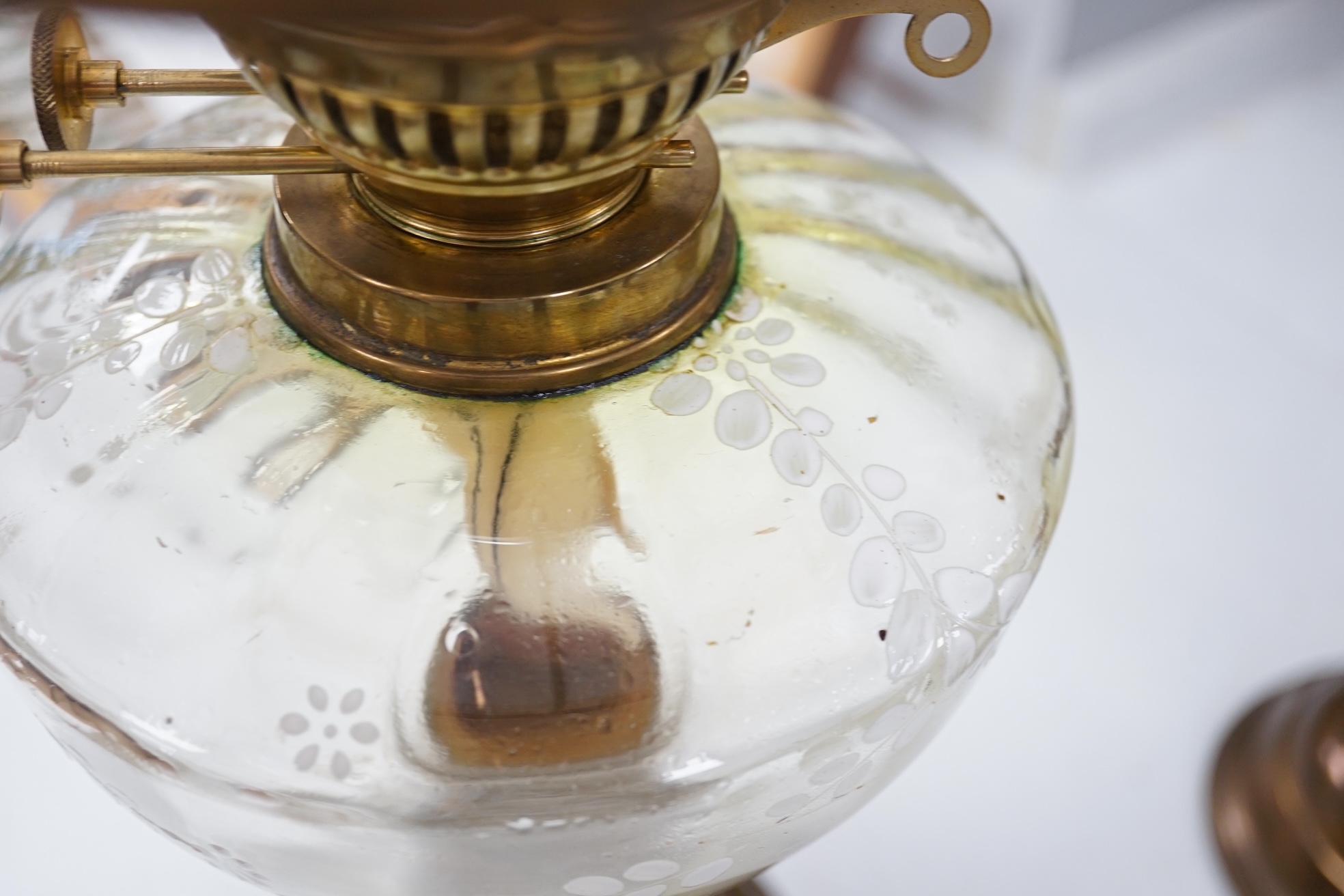 A late 19th century brass oil lamp with painted bowl and opaque shade together with a later oil lamp, largest 59cm high. Condition - fair to good